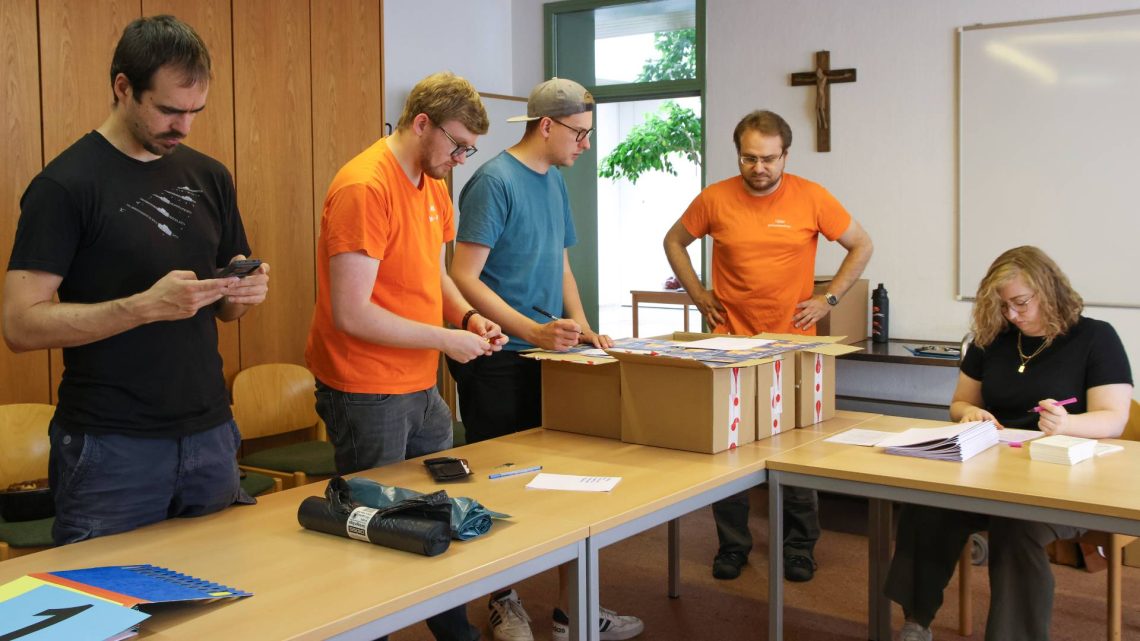 Vorbereitungen für die Romwallfahrt in Erlangen (St. Bonifaz Erlangen): Die Steuerungsgruppe packt Pilgerpakete für die teilnehmenden Ministrantinnen und Ministranten.
Im Bild (v.l.): Benedict Traub, Alexander Zips, Marco Hullin, Tobias Bienert und Marina Lang, Quelle: Pressestelle Erzbistum Bamberg/Patricia Achter