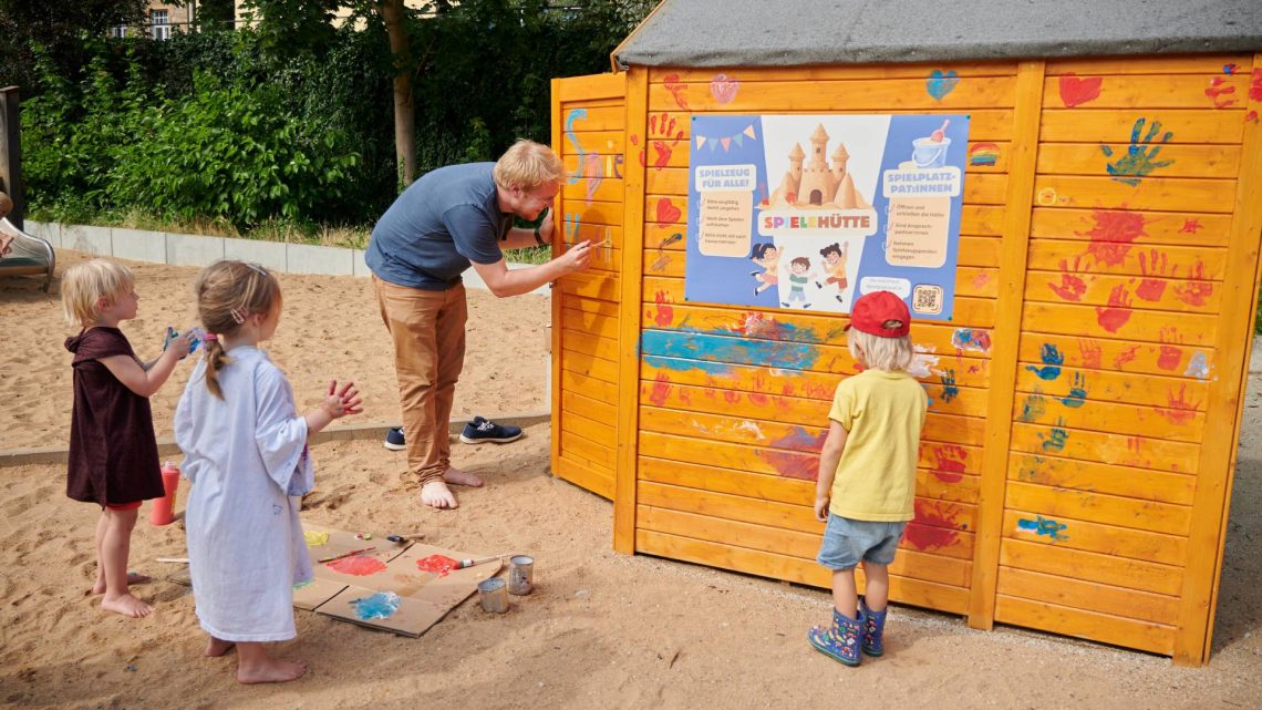 Bei der Eröffnungsfeier wurde die Spielehütte unter Anleitung von Maxi Manlig (mit Pinsel) vom Stadtjugendring mit bunten Handabdrücken verziert, Quelle: Stadt Bamberg, Sonja Seufferth