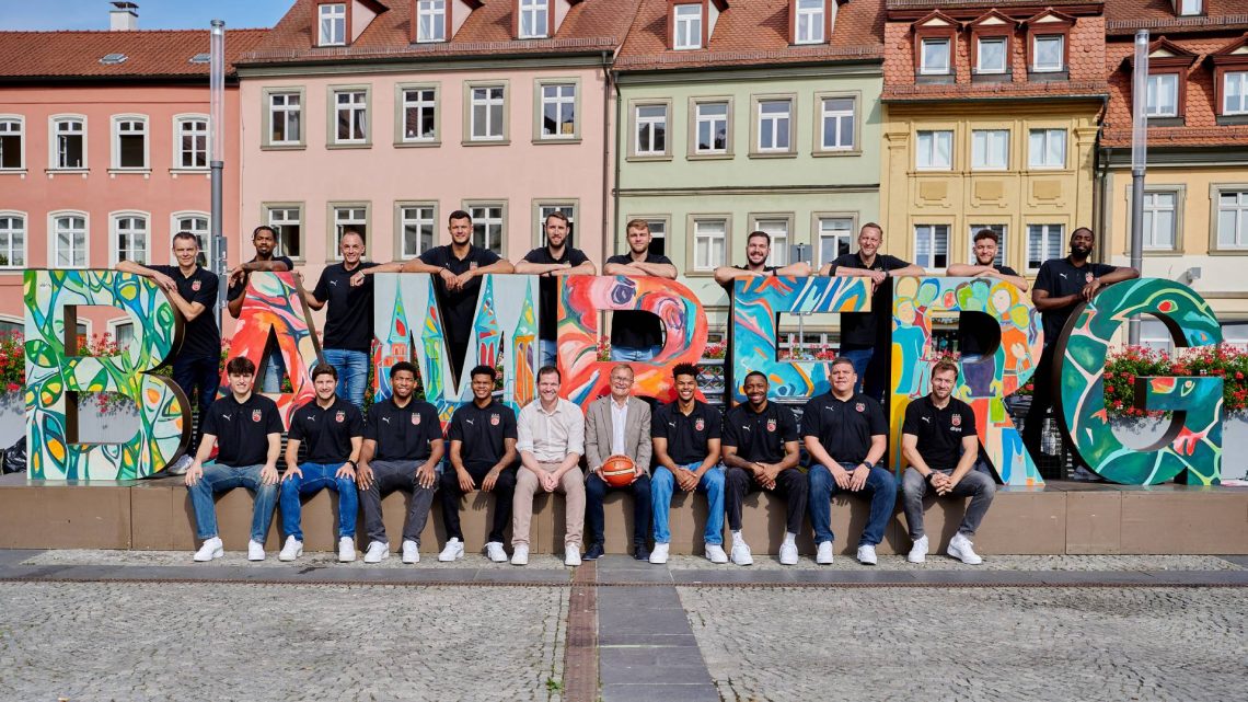 Das Team der Bamberg Baskets mit Oberbürgermeister Andreas Starke (mit Ball): Stefan Weissenböck (Individualtrainer, hintere Reihe von links), Ibrahim Watson (Flügelspieler), Karsten Tadda (Kapitän), Filip Stanić (Center), Brandon Horvath (Power Forward), Moritz Krimmer (Power Forward), Enzo Neck (Teambetreuer), Arne Woltmann (Assistenztrainer), Kevin Wohlrath (Flügelspieler) und KeyShawn Feazell (Center); Adrian Petković (Aufbauspieler, vordere Reihe von links), Marc Olmos (Athletiktrainer), Noah Locke (Aufbauspieler), Ronaldo Segu (Aufbauspieler), Philipp Höhne (Geschäftsführer), Gabriel Kuku (Flügelspieler), Kyle Lofton (Aufbauspieler), Thommy Pike (Physiotherapeut) und Anton Gavel (Trainer), Quelle: Stadt Bamberg, Sonja Seufferth