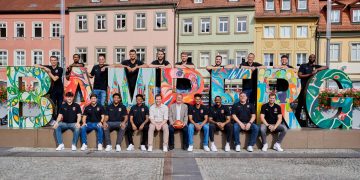 Das Team der Bamberg Baskets mit Oberbürgermeister Andreas Starke (mit Ball): Stefan Weissenböck (Individualtrainer, hintere Reihe von links), Ibrahim Watson (Flügelspieler), Karsten Tadda (Kapitän), Filip Stanić (Center), Brandon Horvath (Power Forward), Moritz Krimmer (Power Forward), Enzo Neck (Teambetreuer), Arne Woltmann (Assistenztrainer), Kevin Wohlrath (Flügelspieler) und KeyShawn Feazell (Center); Adrian Petković (Aufbauspieler, vordere Reihe von links), Marc Olmos (Athletiktrainer), Noah Locke (Aufbauspieler), Ronaldo Segu (Aufbauspieler), Philipp Höhne (Geschäftsführer), Gabriel Kuku (Flügelspieler), Kyle Lofton (Aufbauspieler), Thommy Pike (Physiotherapeut) und Anton Gavel (Trainer), Quelle: Stadt Bamberg, Sonja Seufferth