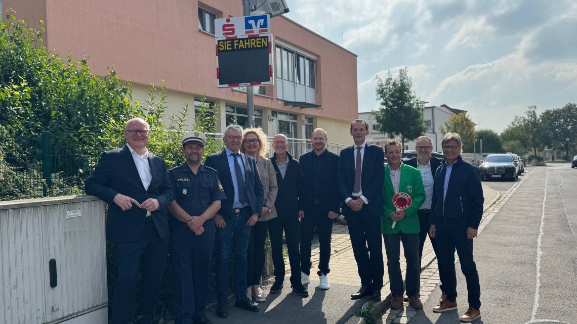 Übergabe der neuen Geschwindigkeitsmessanzeigen an der Schule in Memmelsdorf: (v. l.) Stephan Kirchner (Vorstandsvorsitzender Sparkasse Bamberg), Marco Krieglsteiner (PI Bamberg-Land), Landrat Johann Kalb, Karin Radler-Denzlein (Rektorin der Grund- und Mittelschule Memmelsdorf), Bürgermeister Gerd Schneider, Philipp Beyer (Leiter Fachbereich Straßenverkehr am Landratsamt Bamberg), Thomas Schwarz (Vorstandsmitglied VR Bank Bamberg-Forchheim), Matthias Wenninger (1. Vorsitzender Kreisverkehrswacht Bamberg,) Wolfgang Kohn Marketingleiter bei VR Bank Bamberg-Forchheim, Mathias Polz, Pressesprecher Sparkasse Bamberg), Quelle: Landratsamt Bamberg/Bartl