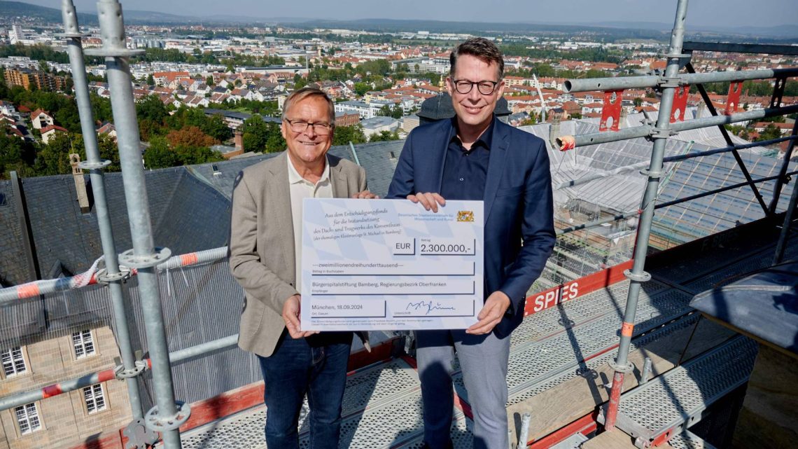 Bayerns Staatsminister Markus Blume übergab an Oberbürgermeister Andreas Starke auf dem Gerüst des nördlichen Kirchturms den Zuwendungsbescheid aus dem Entschädigungsfonds Bayern für die Dachsanierung des Konventbaus des ehemaligen Klosters St. Michael, Quelle: Stadt Bamberg, Sonja Seufferth