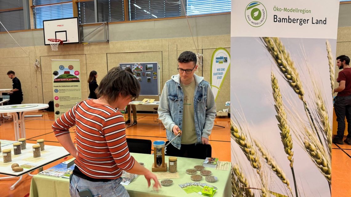 Austausch mit Manager Patrick Nastvogel am Infostand der Öko-Modelregion, Quelle: Naturpark Steigerwald / V. Kritikos