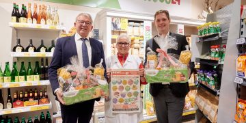 Landrat Johann Kalb mit Marktleiterin Anne Rudel und Zweiten Bürgermeister Jonas Glüsenkamp vor dem Regal der Genusslandschaft im Rewemarkt Rudel, Quelle: Stadt Bamberg, Sonja Seufferth