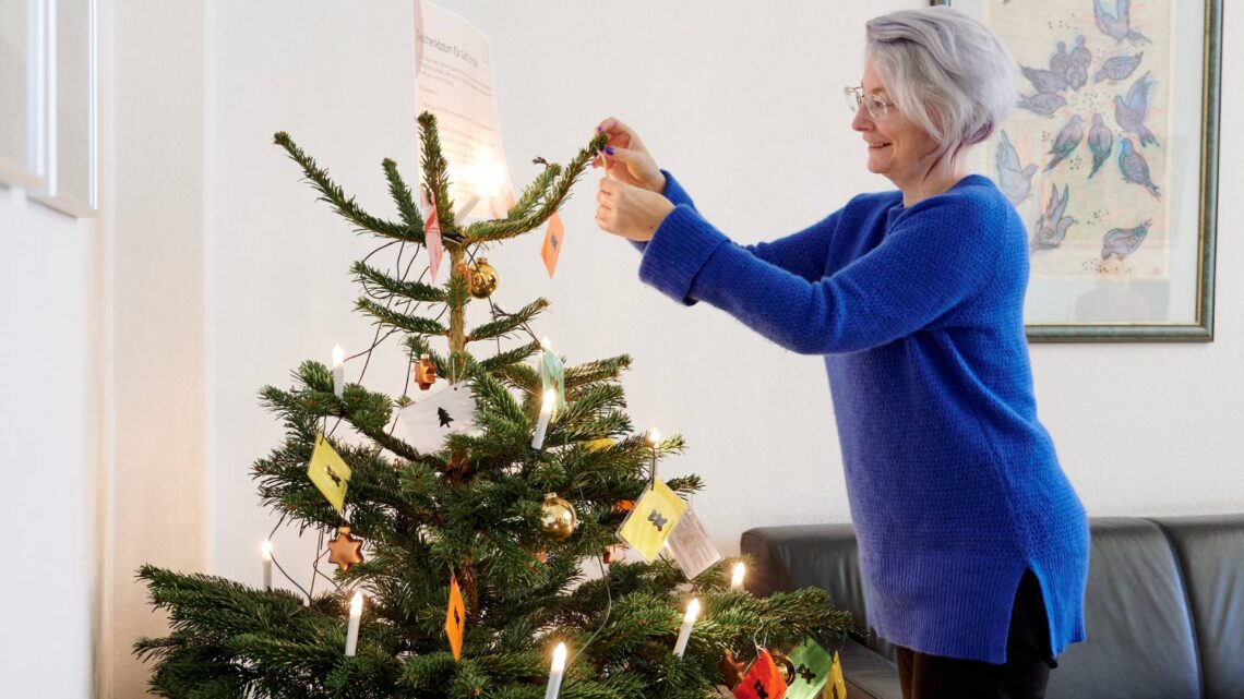 Simone Oswald von Freund statt fremd beim Schmücken des Geschenkbaums
im Vorzimmer von Oberbürgermeister Andreas Starke. Bis 18. Dezember 2024
können Wünsche von geflüchteten Kindern erfüllt werden. Quelle: Stadt Bamberg, Sonja Seufferth