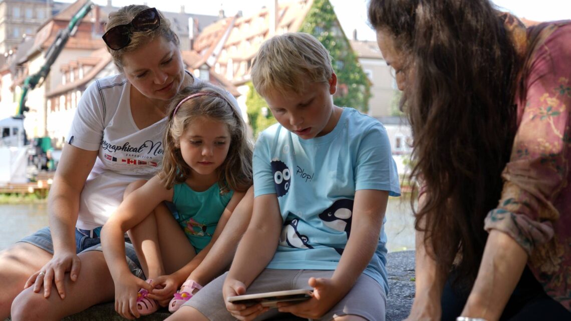 Laura und Alexander (Mitte) haben die App bereits gemeinsam mit ihrer Mutter Katharina Ebner (l.) getestet. Mit dabei war auch Nora Heyne (r.), die die App entwickelt hat. Quelle: Hannah Fischer/Universität Bamberg