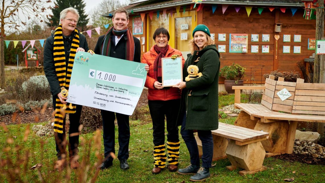 Zweiter Bürgermeister Jonas Glüsenkamp übergibt die
Preisurkunde an Ilona Munique und Reinhold Burger an der BienenInfoWabe. Quelle: Stadt Bamberg, Sonja Seufferth