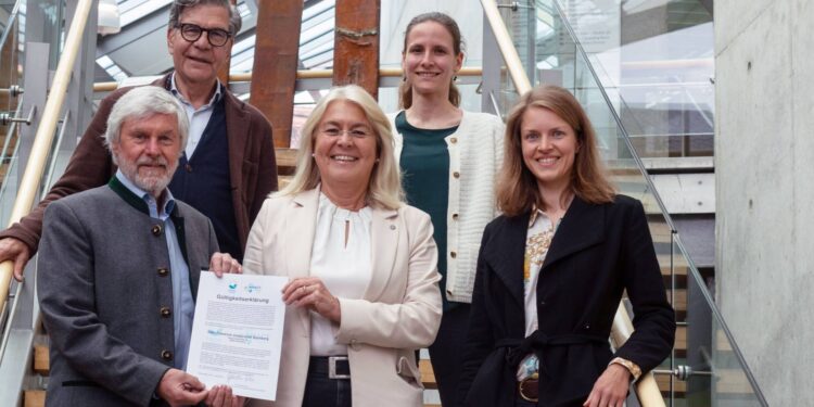 Die Gutachter Günther Rau (vorne l.) und Burkhard Kühnemann (hinten l.) übergeben die Gültigkeitserklärung an Kanzlerin Dagmar Steuer-Flieser (Mitte) und Antonia Schott-Bartning (vorne r.) und Theresa Riedl (hinten r.). Quelle: Emma Seeger/Universität Bamberg