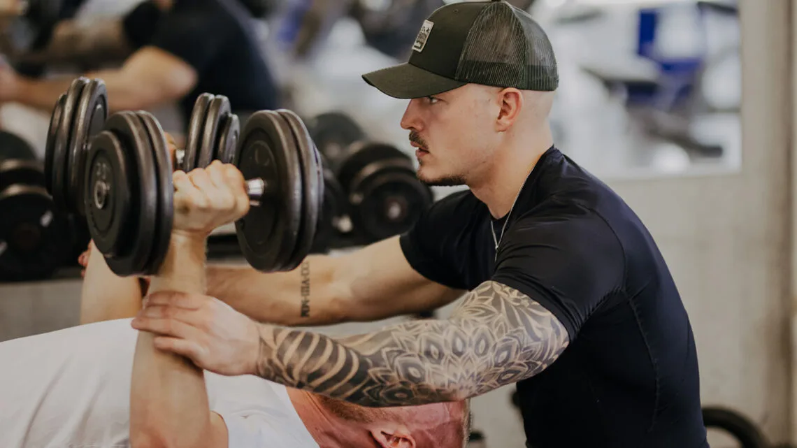 Fitnesscoach Yannick Reinlein beim Personal Training im Fitnessstudio.