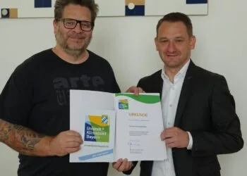 Landrat Johannes Maciejonczyk überreicht die Urkunde zum „Umweltpakt Bayern“ an Gitarrenbaumeister Thomas Ochs. (Quelle: Landratsamt Bamberg)