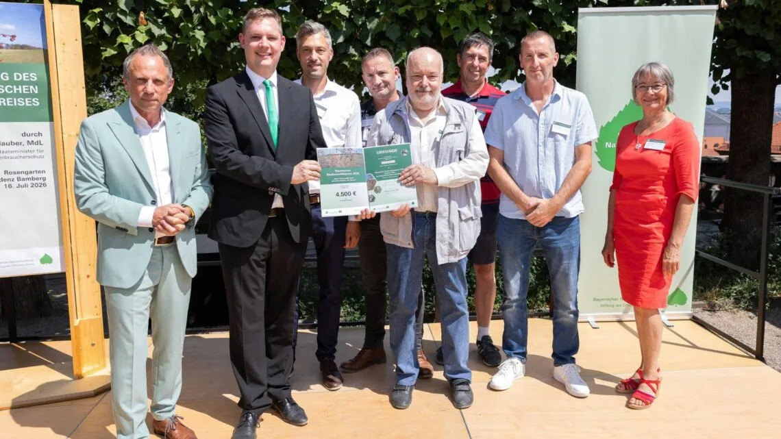 Umweltminister Thorsten Glauber mit
Bürgermeister Jonas Glüsenkamp (v.l.), den Beteiligten des Projektes
des „ökologischen Grünflächenmanagements Straßenränder auf
Terrassensand“ und Ulrike Strohmeier, Vorständin des Bayerischen
Naturschutzfonds (r.). Quelle: Bayerisches Staatsministerium für Umwelt- und
Verbraucherschutz (STMUV)