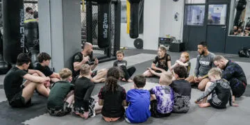 Rund 100 Kinder und Jugendliche auf der Matte: Warum Kampfsport bei GYMRAY in Bamberg so gut ankommt 12 Kinder und Jugendliche sitzen mit ihren Trainern beim BJJ-Kindertraining bei GYMRAY in Bamberg auf der Matte.